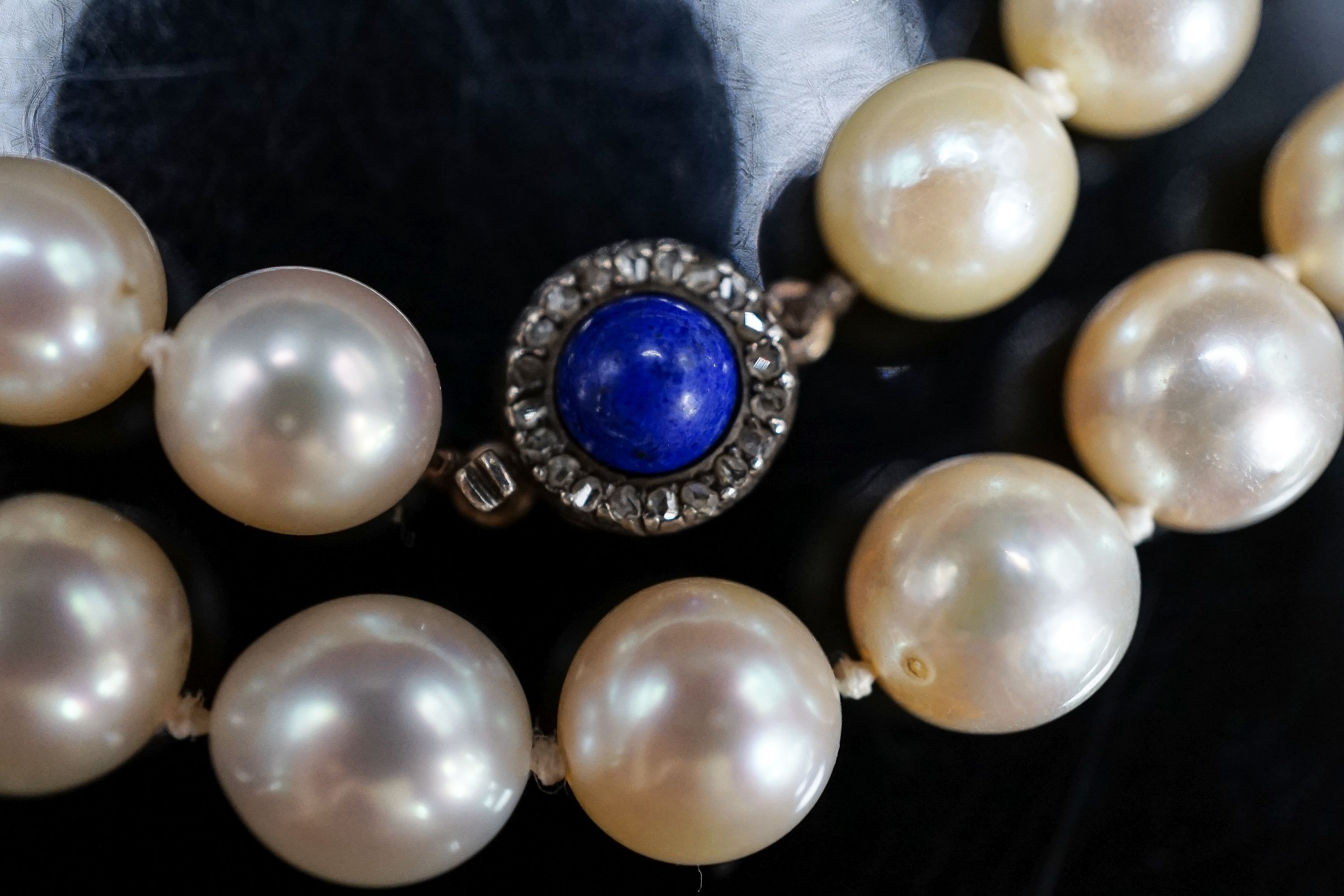 A single strand cultured pearl necklace, with yellow metal, lapis lazuli and diamond set clasp, 63cm, gross weight 67.1 grams.